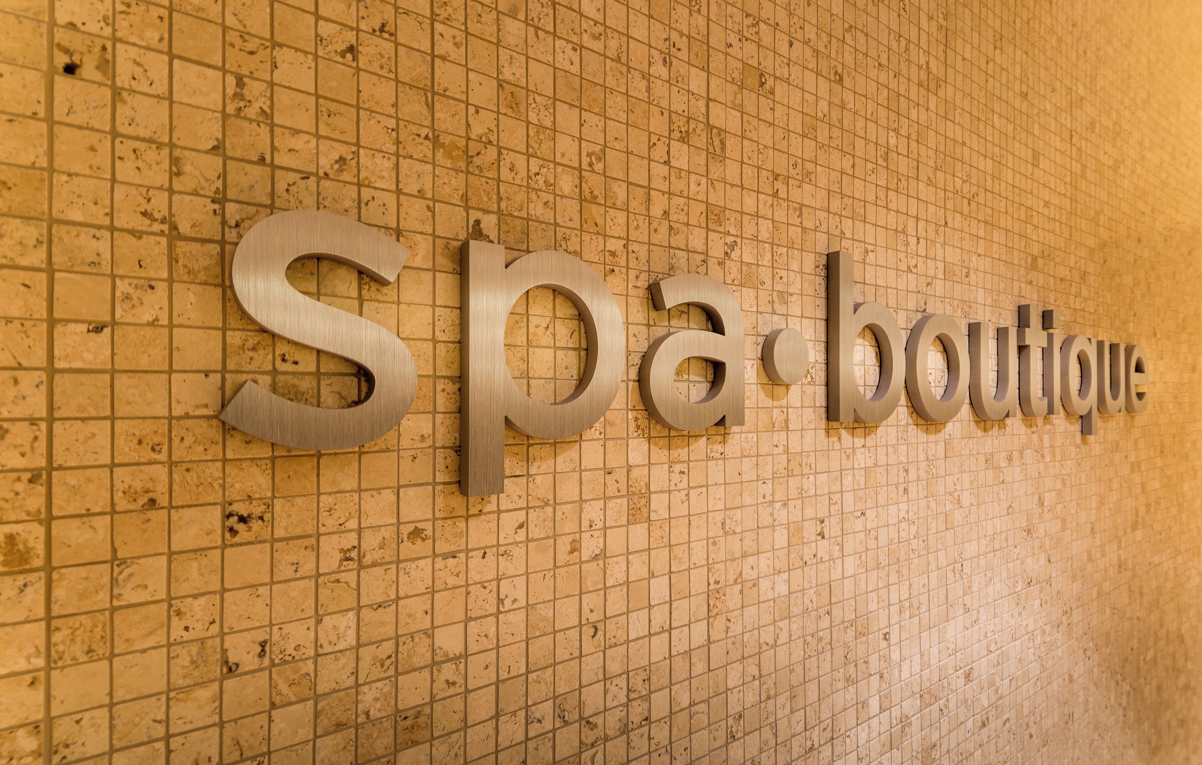 Una pared con las palabras "Spa boutique" en letras grandes y metálicas.