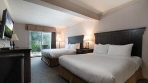 A hotel room with two beds, a TV, a desk, and a balcony with a view. - Prestige Inn Nelson (Nelson)