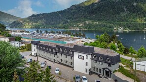 A hotel with a traditional architectural style, located near a lake with boats. - Prestige Inn Nelson (Nelson)