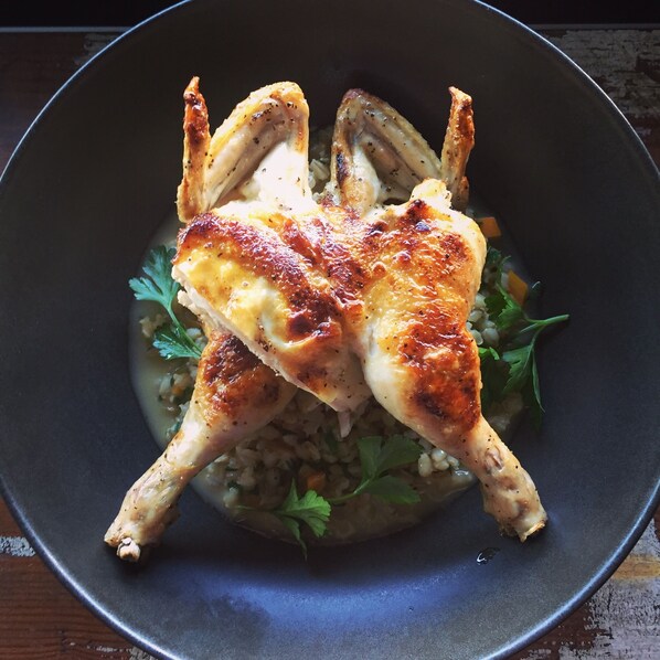 A roasted chicken on a bed of rice garnished with herbs. - Wisemans Retreat (Wisemans Ferry)