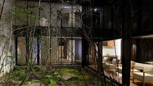 Un interior moderno con una zona de estar, un sendero de piedra y vistas al exterior.