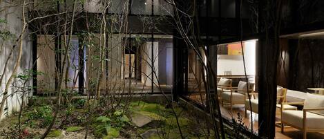 A modern interior with a seating area, a stone pathway, and a view of the outside.