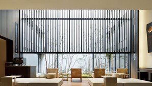 A modern interior with a large window, a sofa set, and a wooden table.