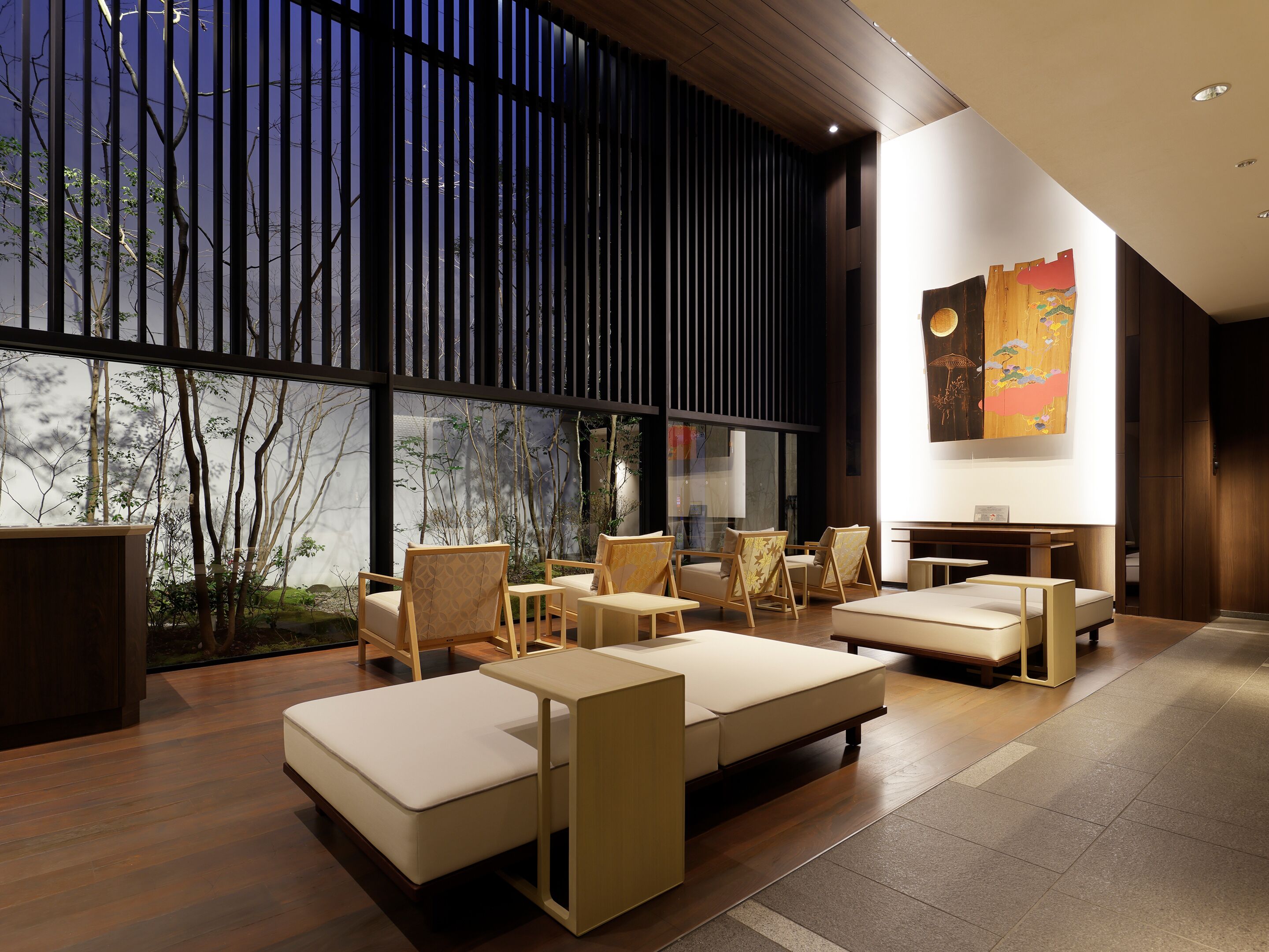 A modern interior with a seating area, large windows, and a wooden floor.
