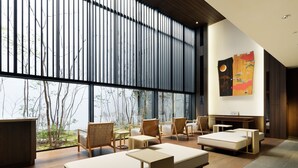 A modern interior with large windows, wooden flooring, and a mix of seating options including sofas and chairs.