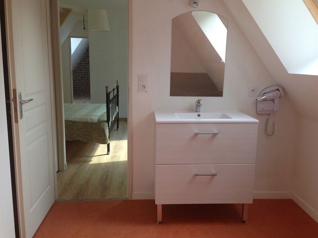 A bedroom with a white vanity, a mirror, and a telephone.