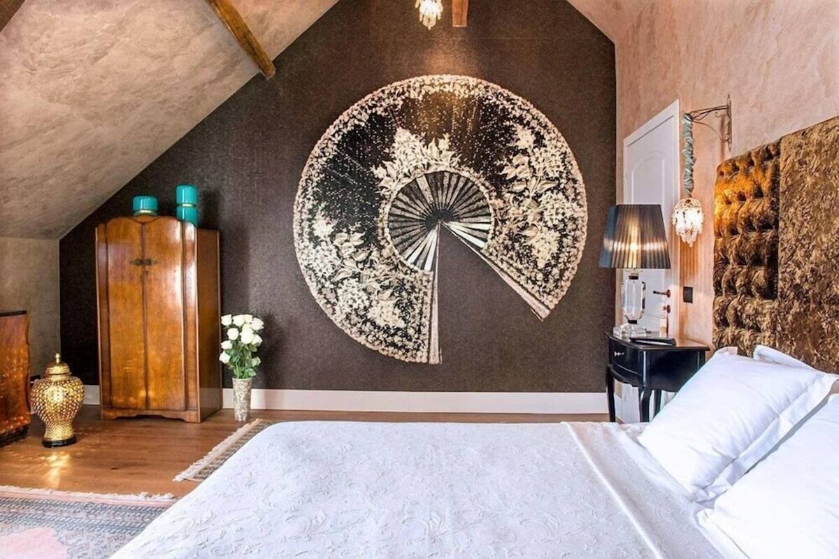 Ein Schlafzimmer mit einem großen Bett, einem runden Wandbild, einem Holzschrank, einem Nachttisch und einer Lampe.