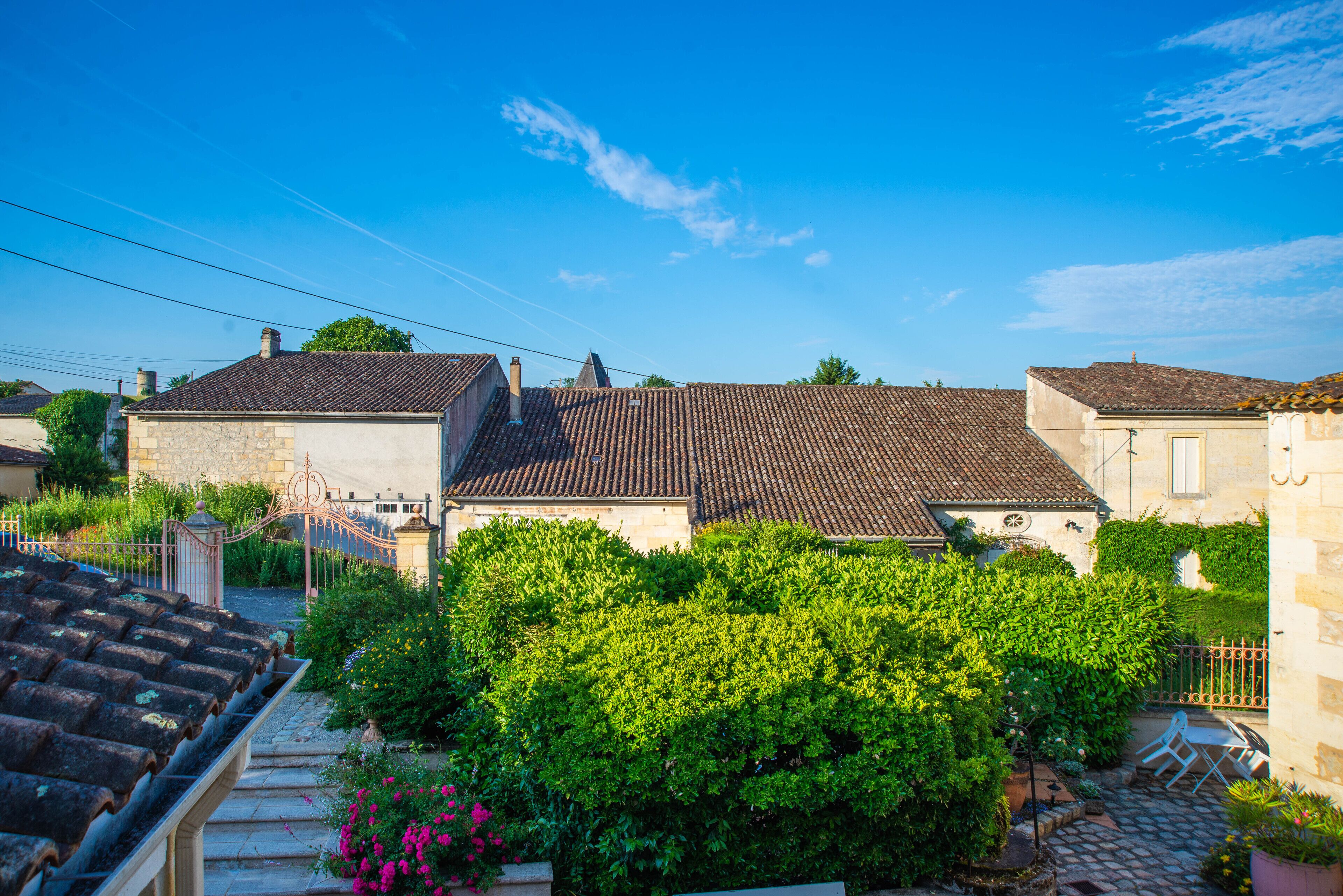 A traditional European village with stone buildings, a cobblestone street, and lush greenery.