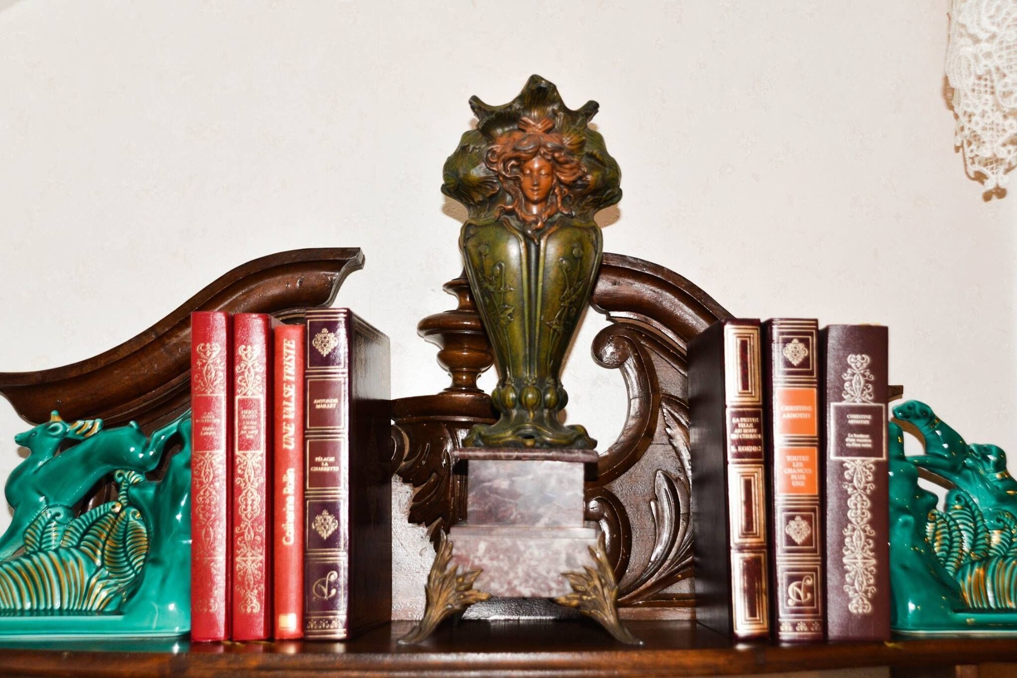 A wooden bookshelf with books and decorative items.