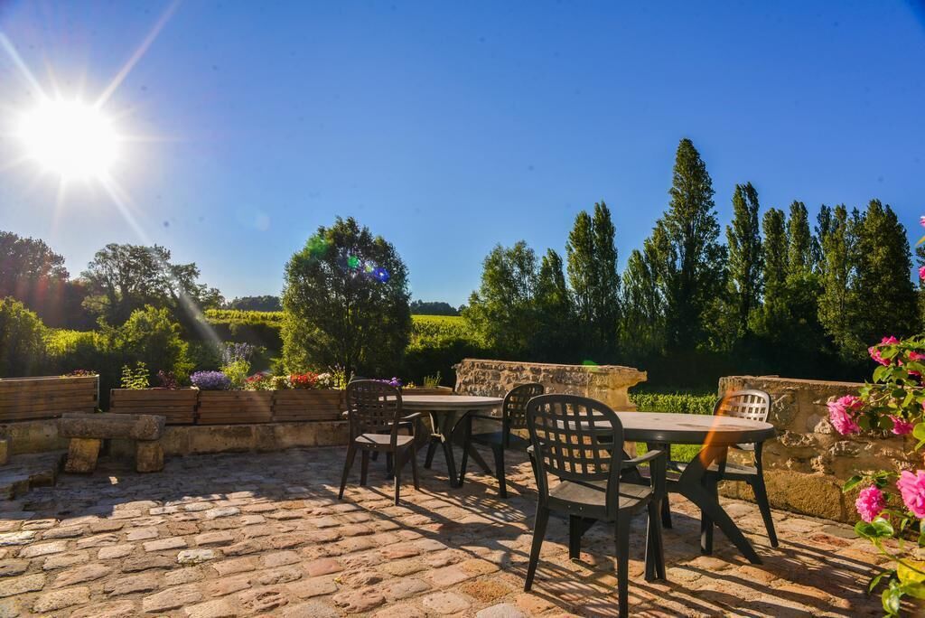 Eine Terrasse im Freien mit Steinböden, einem Tisch und Stühlen.