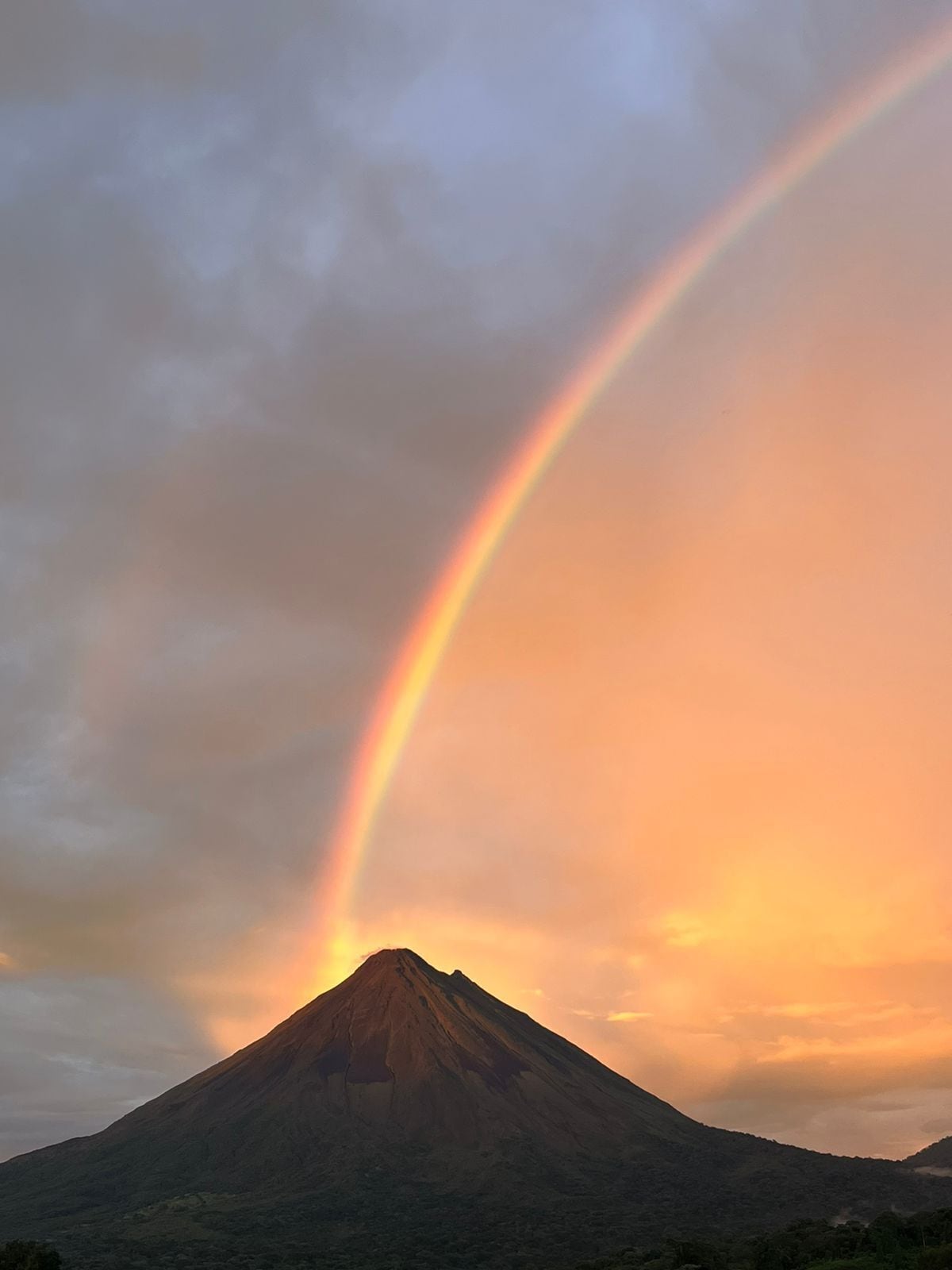 A mountain with a rainbow arching over it.