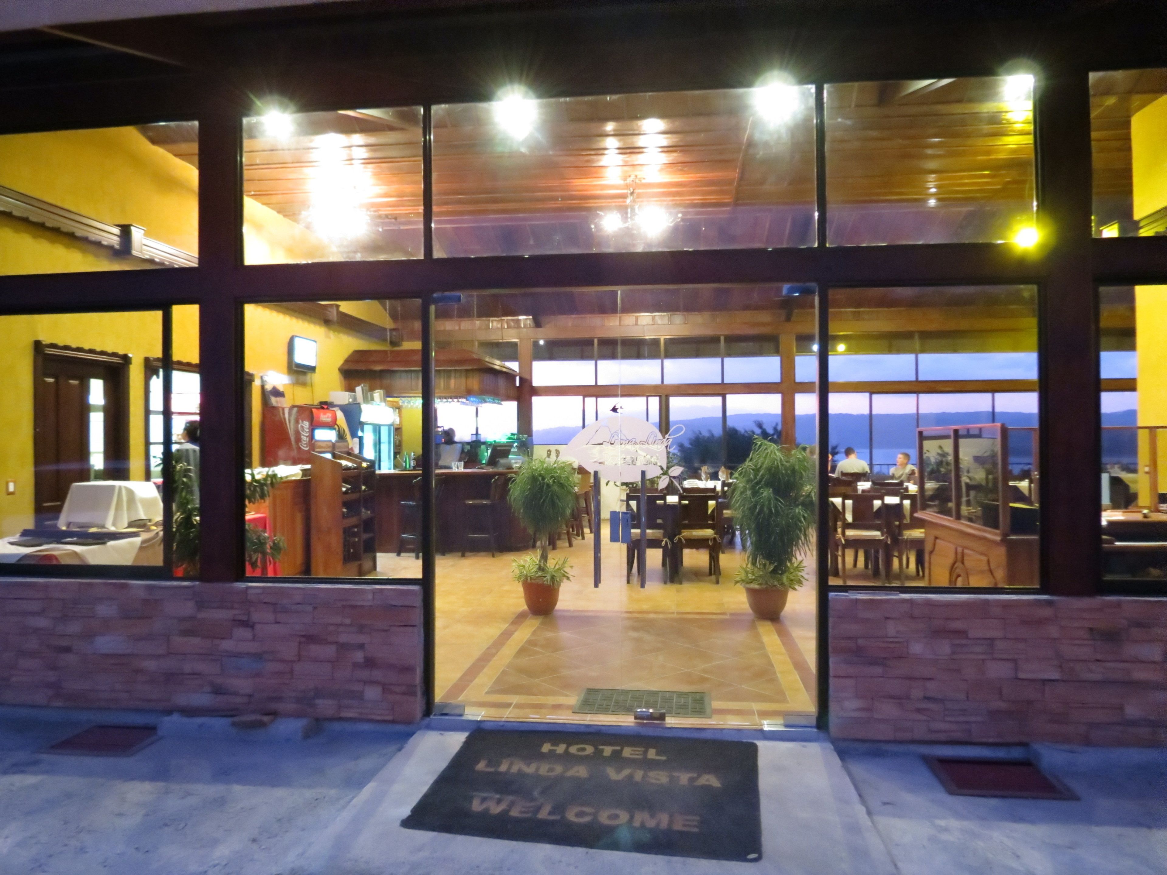 A hotel entrance with a view of the interior, including a bar and dining area.