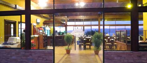 A hotel entrance with a view of the interior, including a bar and dining area.
