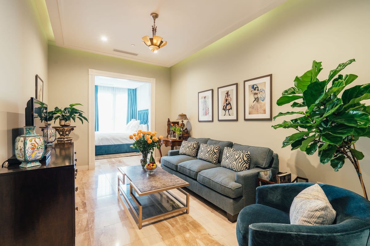 A modern living room with a sofa, armchair, coffee table, and decorative items.