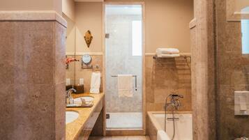 A modern bathroom with a marble sink, a glass-enclosed shower, and a bathtub.