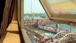 A view from a window overlooking a riverside area with a bridge and a Ferris wheel. - Hotel Gyan (Haridwar)