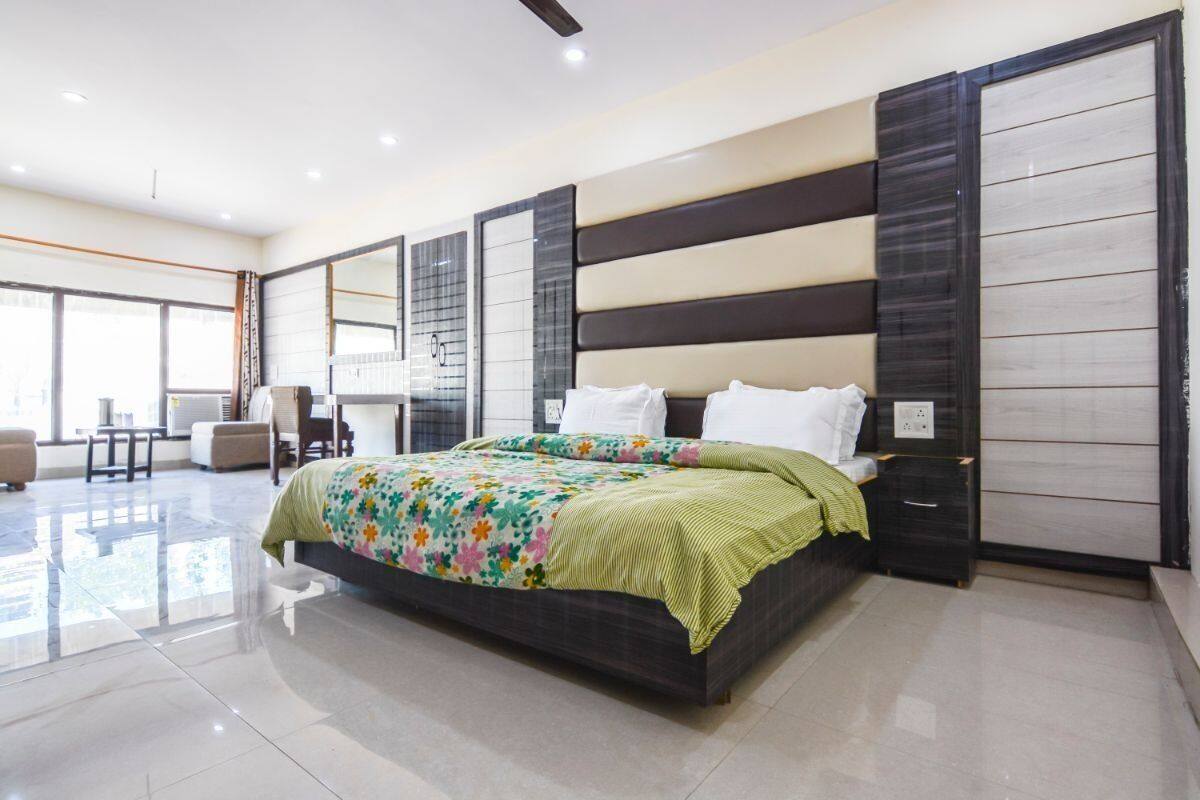 A modern bedroom with a large bed, a desk, and a chair.