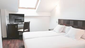 Un dormitorio con cama, escritorio, silla y televisor.