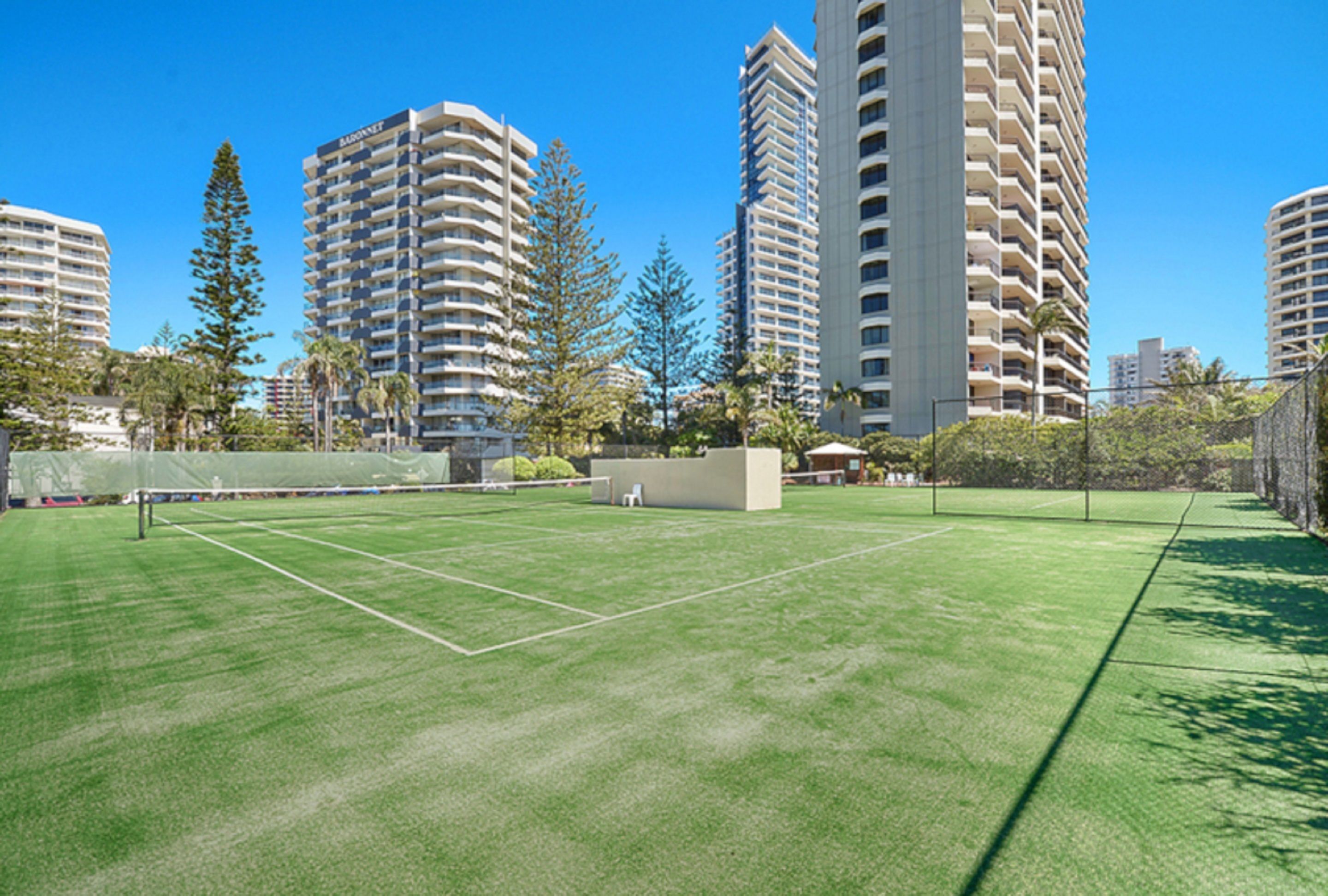 Un campo da tennis circondato da alti edifici.