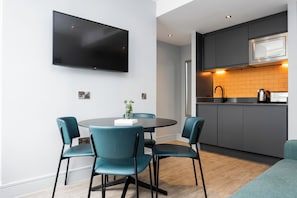 A modern kitchen with dark cabinets, a built-in microwave, and a sink. - Staycity Aparthotels, London, Deptford Bridge (London)