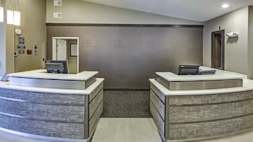 A reception area with two counters, a patterned wall, and a door leading to another room.