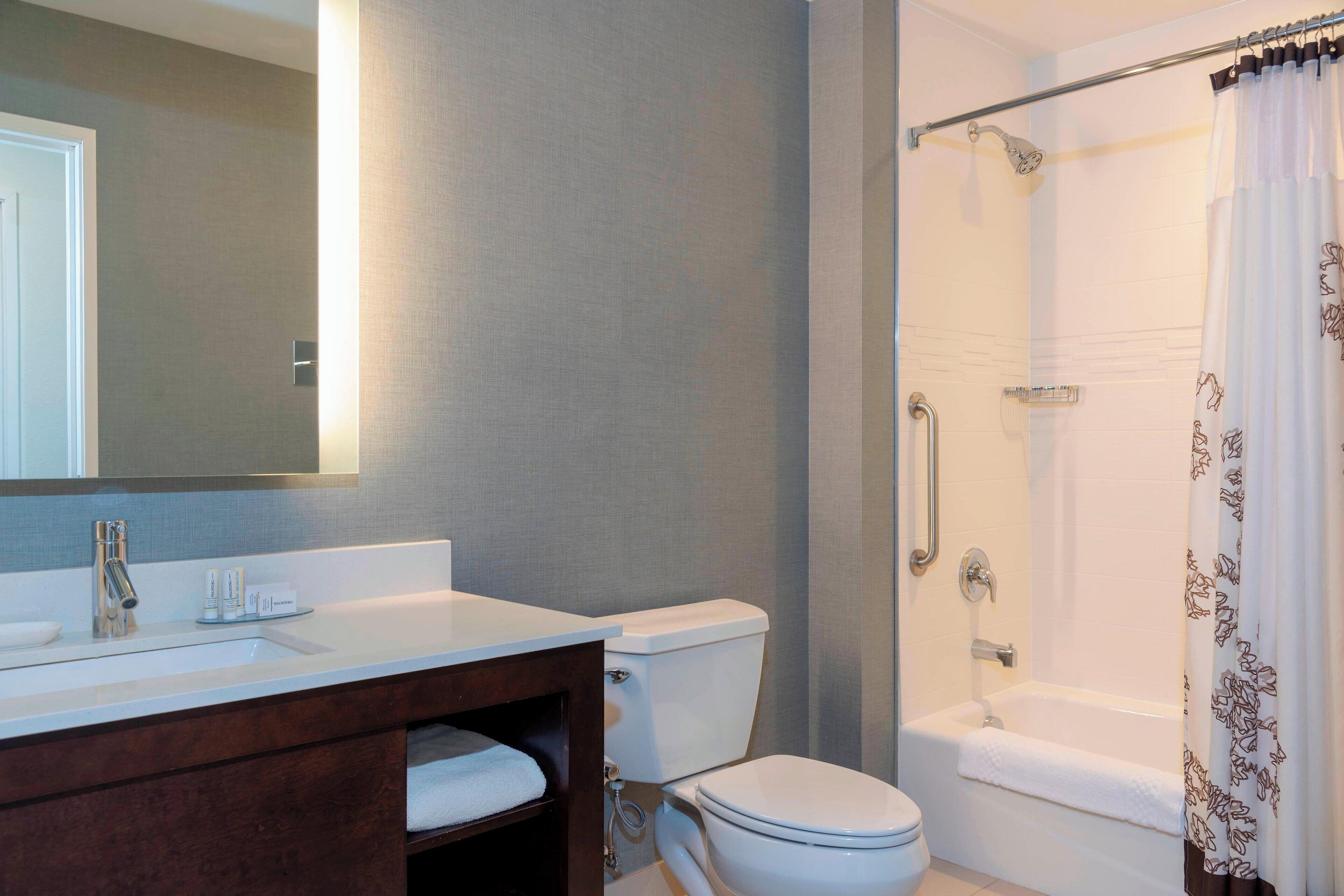 A bathroom with a white sink, mirror, and toilet, a shower with a glass door, and a bathtub.
