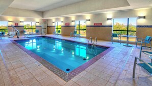 An indoor swimming pool with clear lane markings, a lifeguard chair, and a no diving sign.