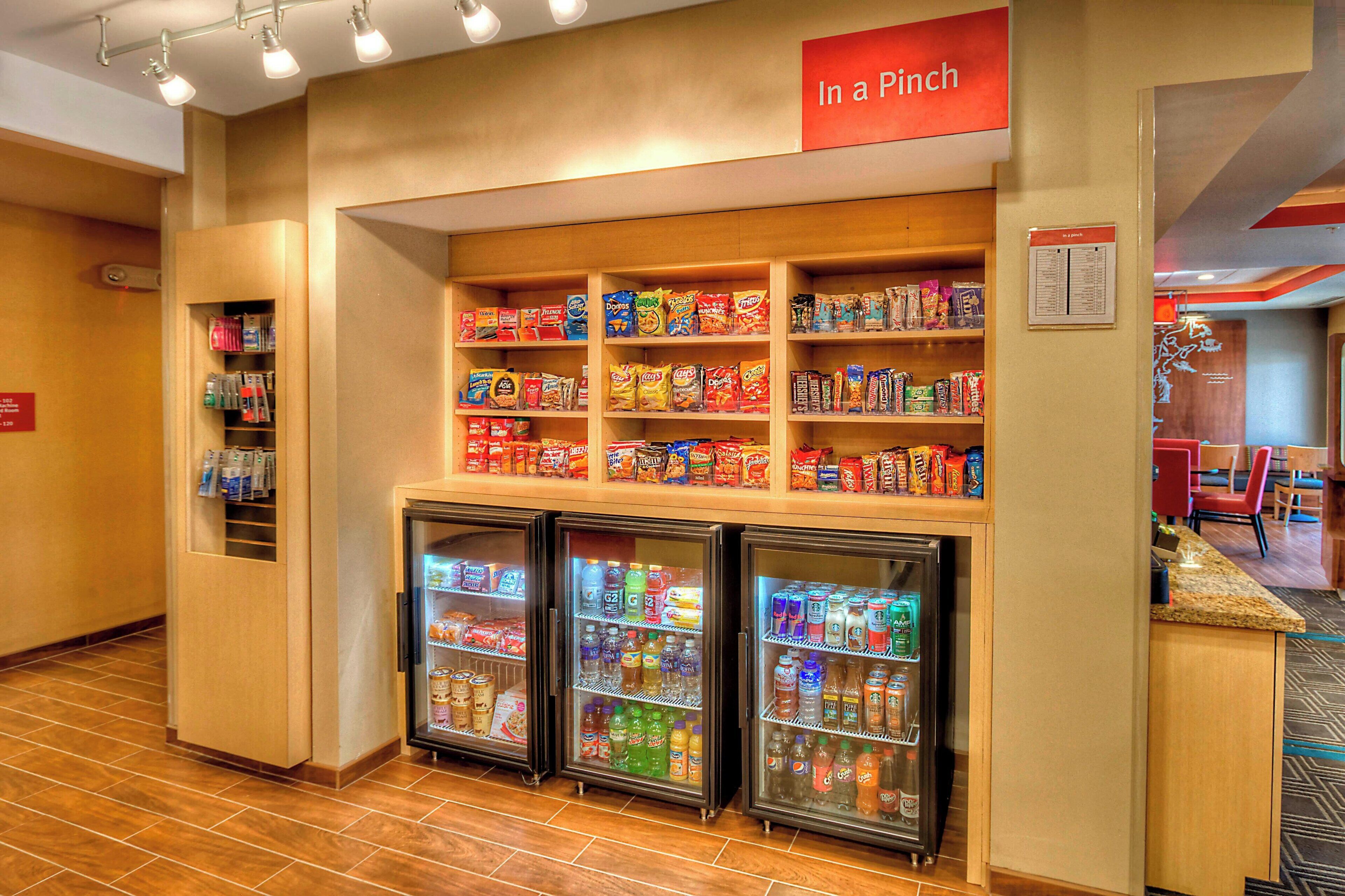 A snack bar with shelves of snacks and beverages, a sign reading "In a Pinch", and a seating area with a counter.