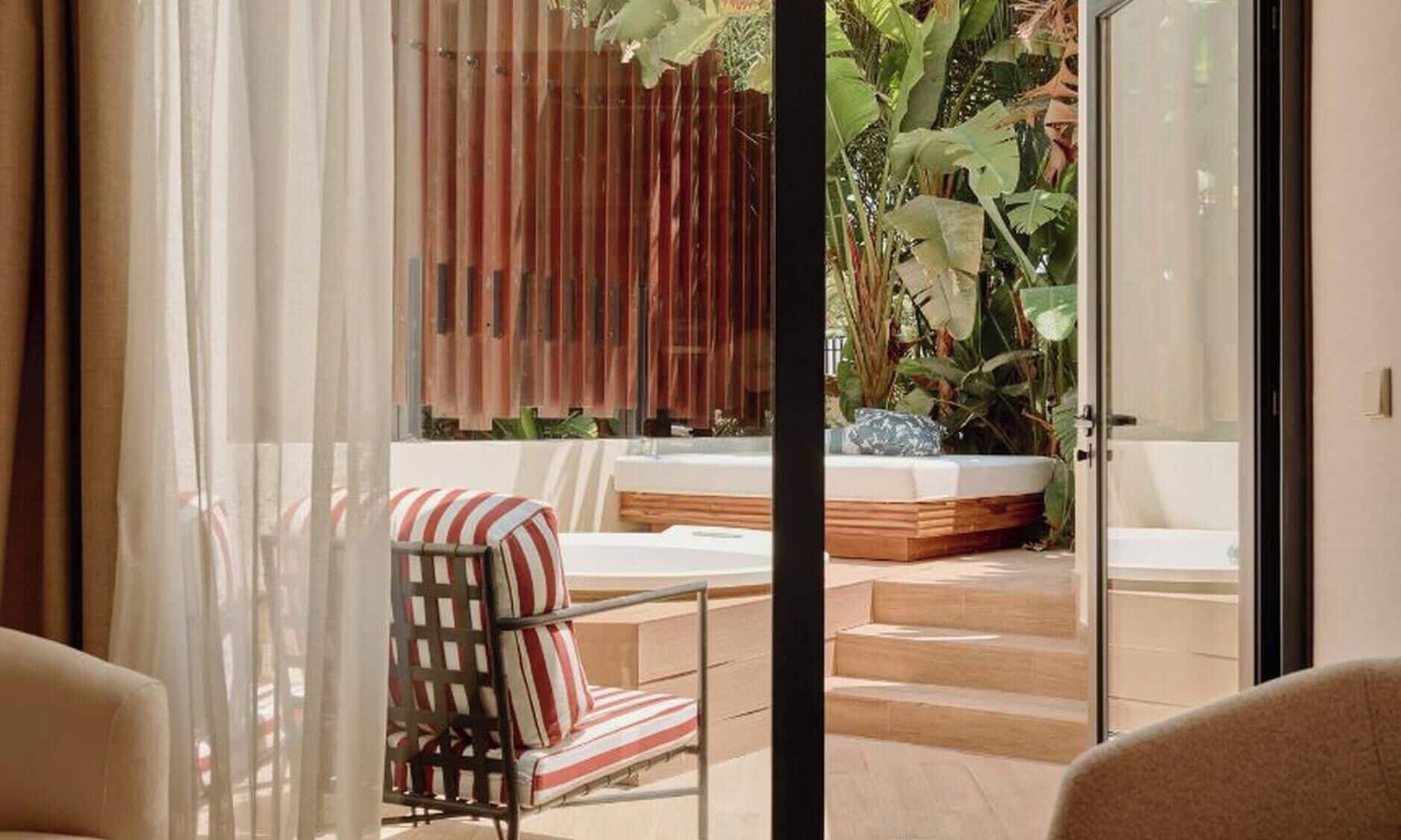 A modern outdoor seating area with a cushioned chair and a hot tub.