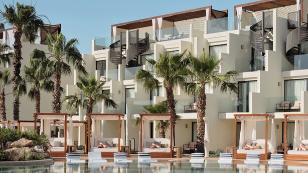 Un resort con piscina, varios balcones y palmeras.