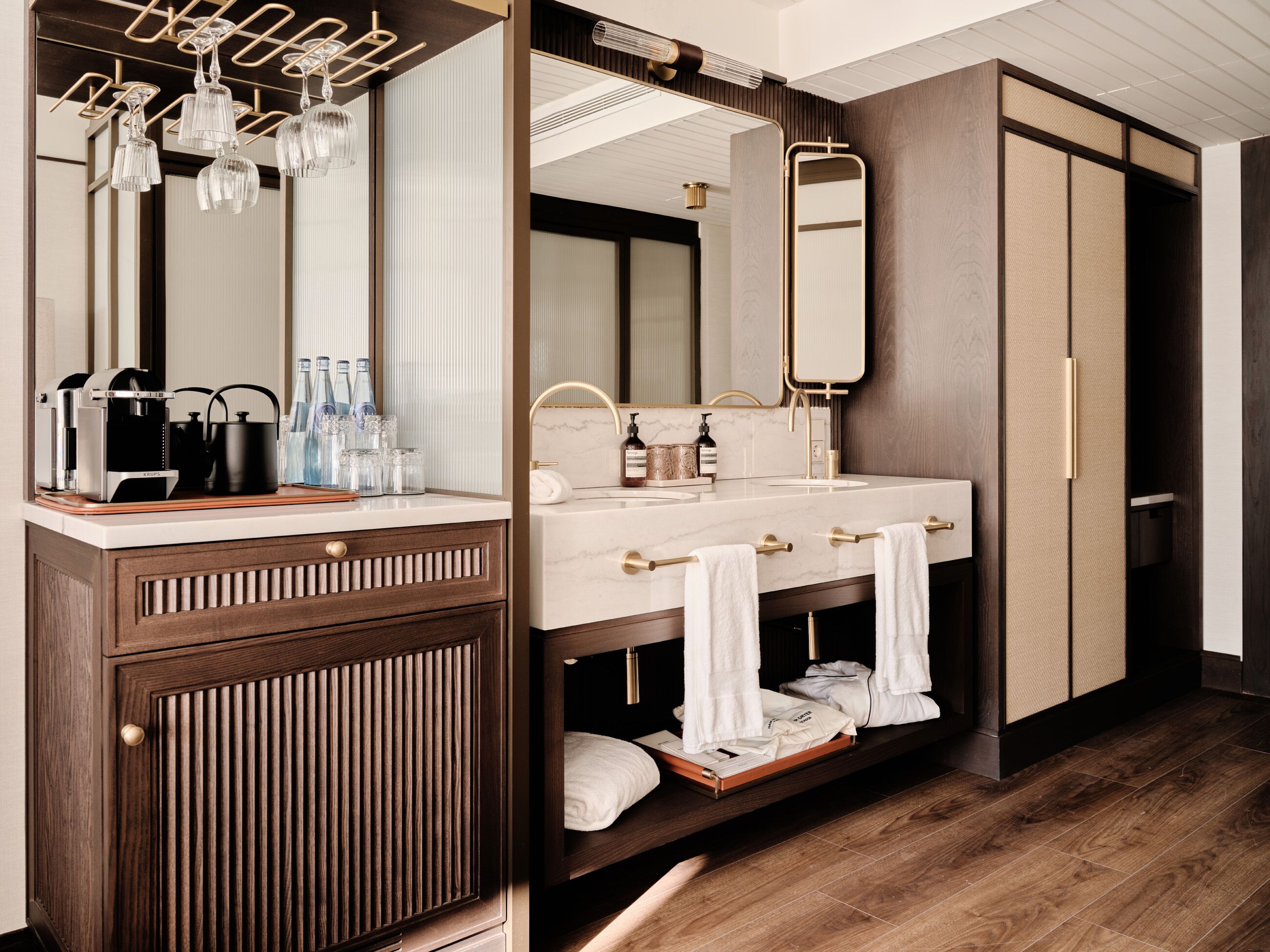 Un baño moderno con tocador de madera, un espejo grande y zona de ducha integrada.