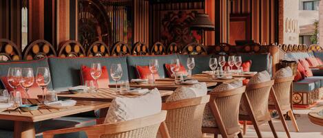 A restaurant with wooden furniture, a patterned ceiling, and a view of the street.