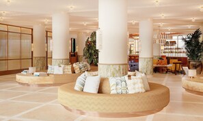 A spacious lobby with a central seating area, large columns, and a bar in the background. - BLESS Ibiza The Site - New Opening 2026 (Sant Josep de sa Talaia)