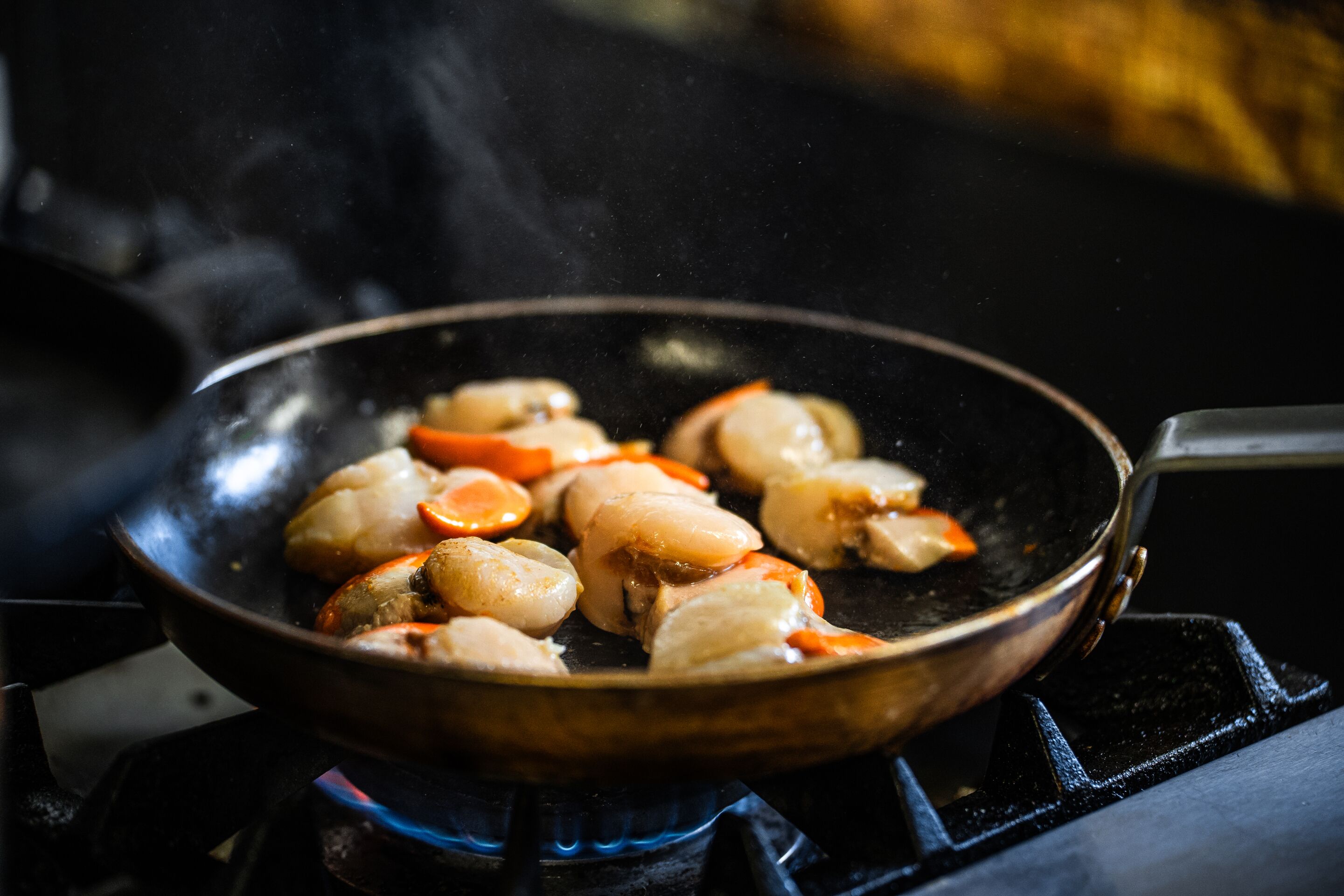A frying pan on a stove with food being cooked.