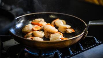 A frying pan on a stove with food being cooked.