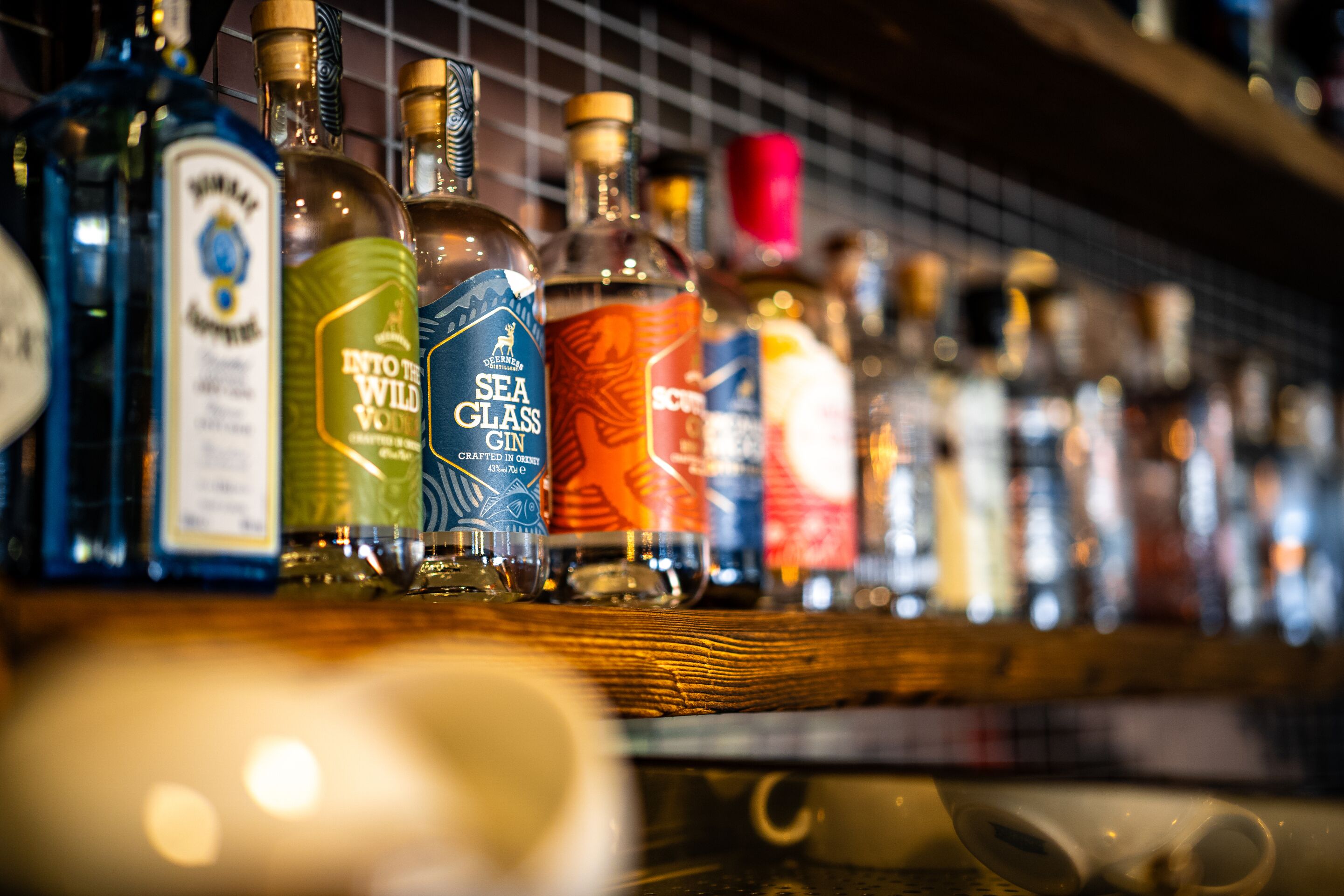 Variedad de botellas de licor en una estantería de bar.