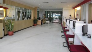 A modern reception area with a reception desk, seating area, and a clear view of the entrance. - Promenade Service Apartments (Kota Kinabalu)