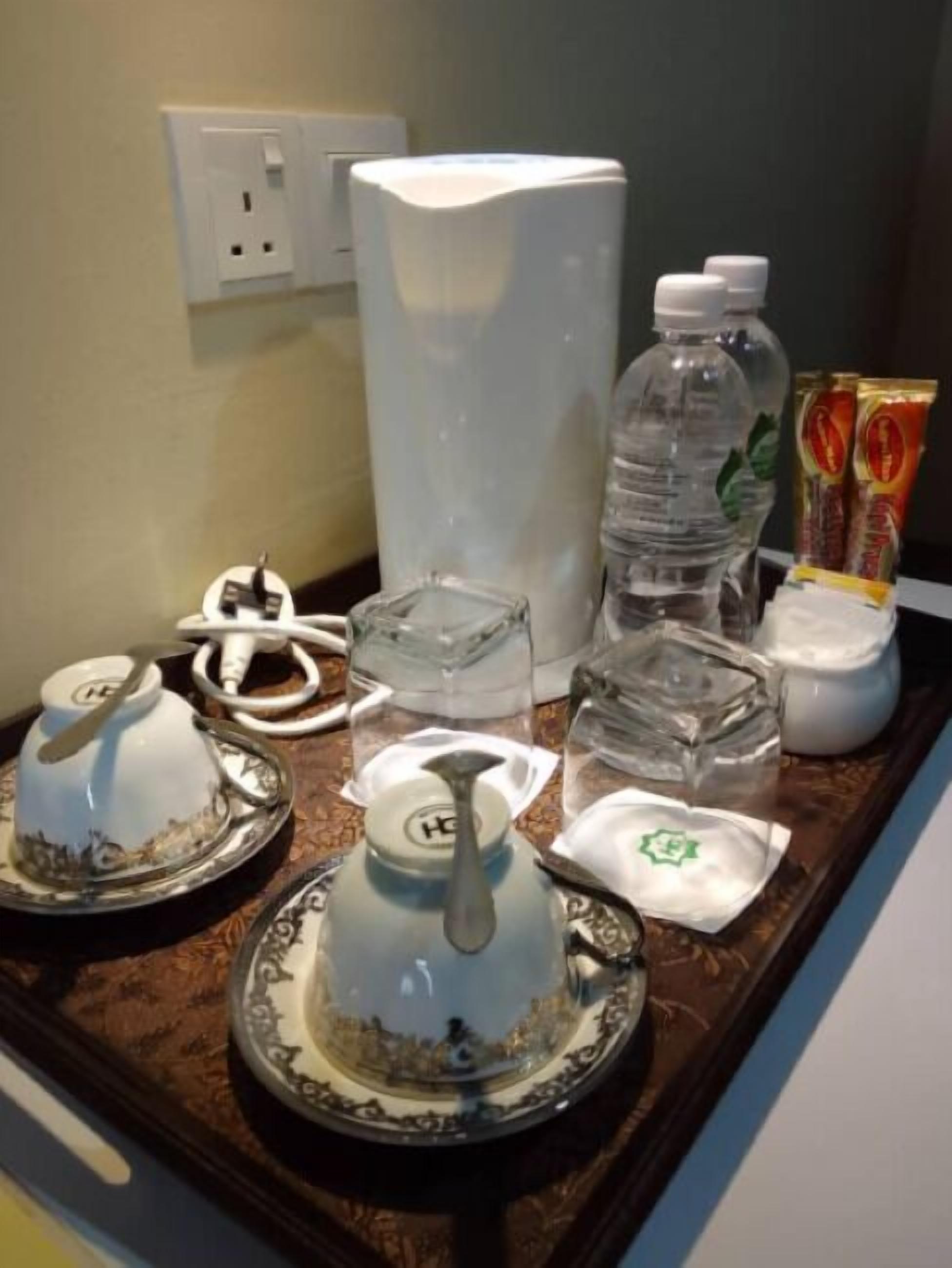 Eine Küchenarbeitsplatte mit Kaffeemaschine, Wasserflaschen, Teebeuteln und einem Wasserkocher.