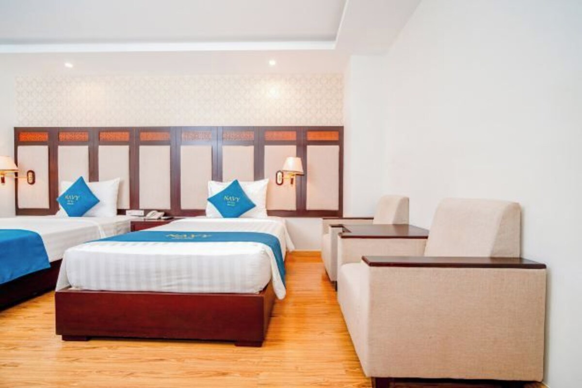 Una habitación de hotel con dos camas, un sofá y un escritorio.