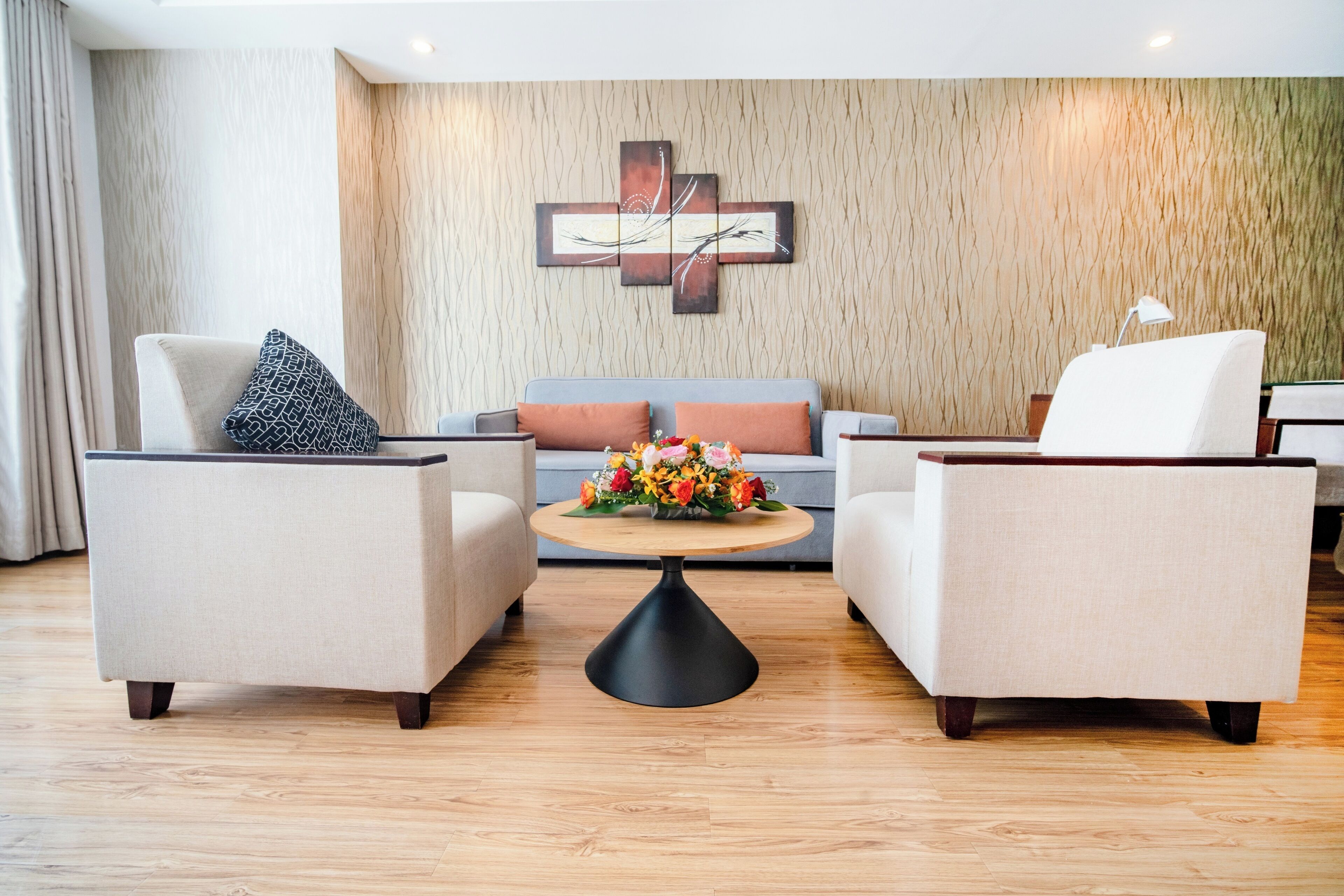 A modern lobby with two sofas, a coffee table, and a wall-mounted artwork.