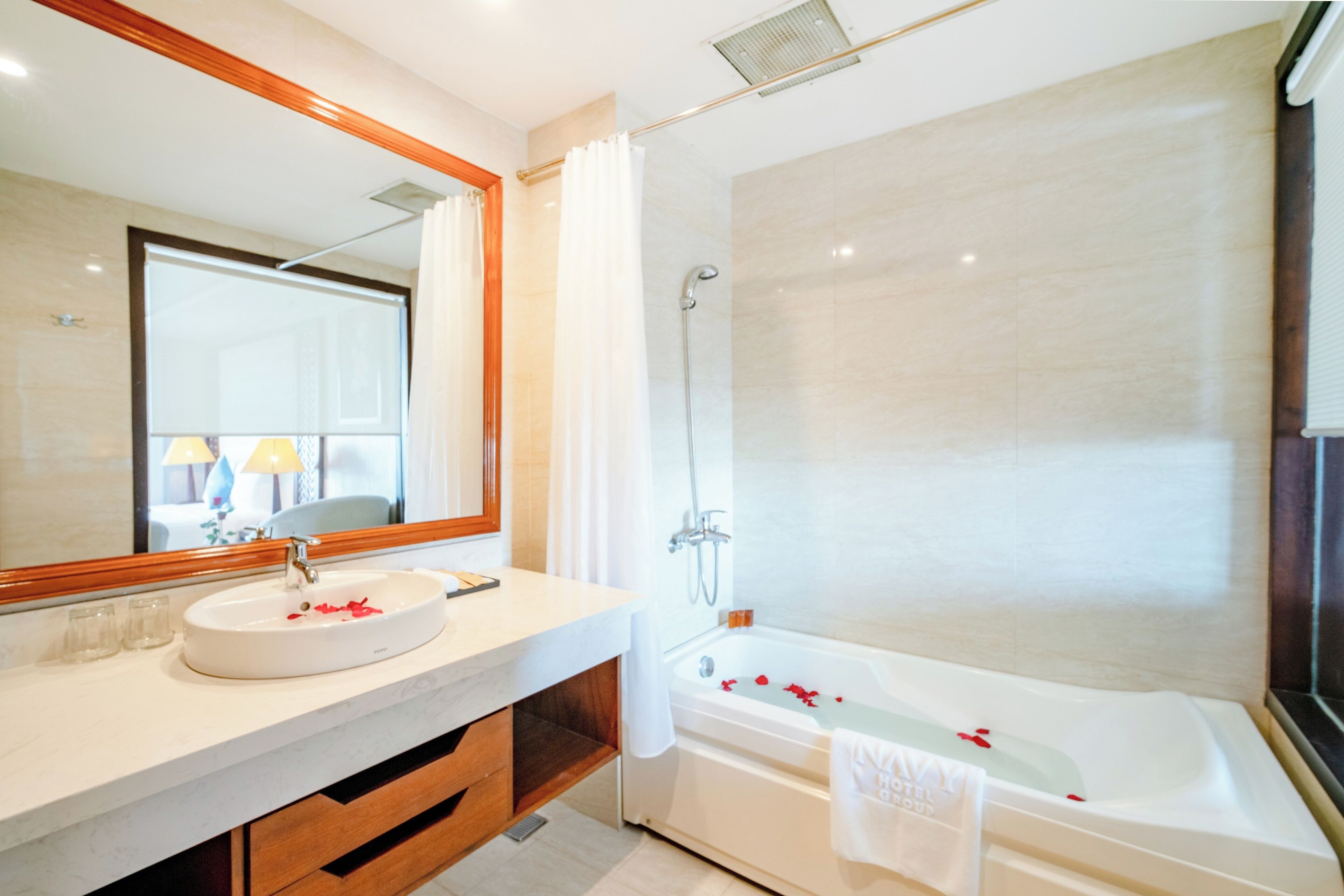 Ein modernes Badezimmer mit großem Spiegel, Waschbecken und Badewanne.
