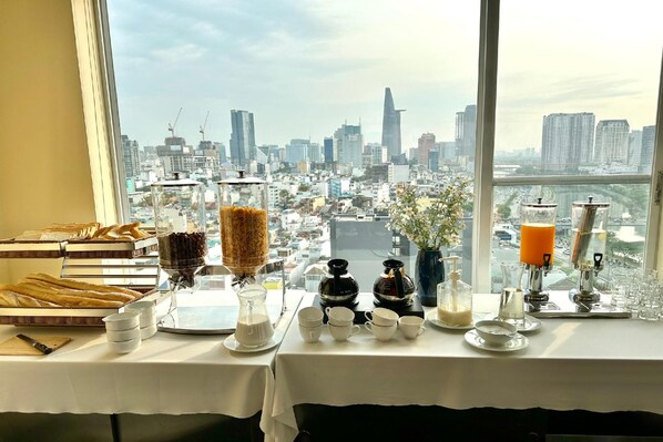 Enjoy breakfast with a city view, surrounded by a selection of pastries, coffee, and refreshments.