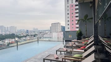 Una piscina al aire libre, sillones reclinables de piscina