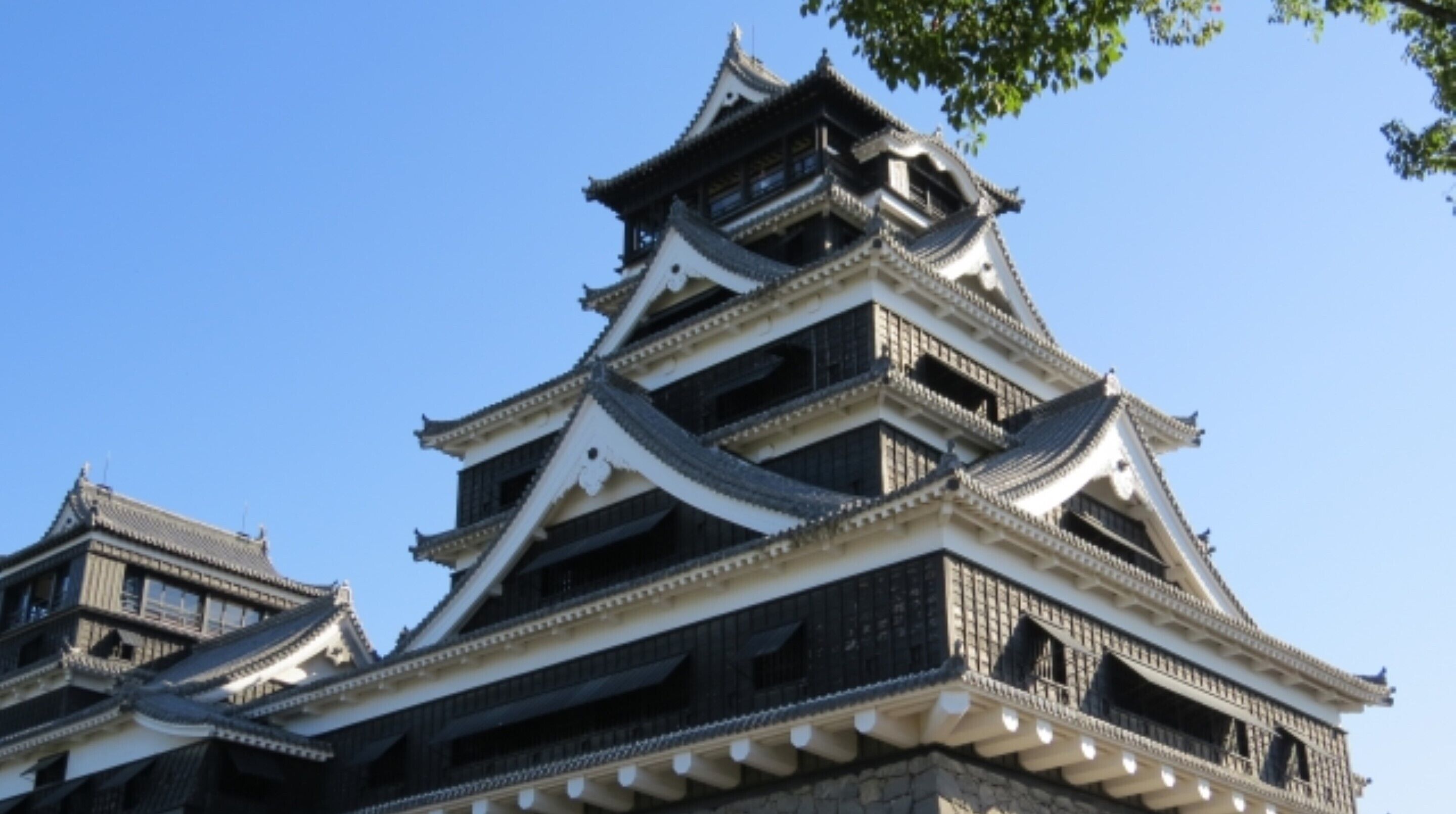 Un château japonais traditionnel, doté de plusieurs niveaux et de détails architecturaux richement décorés.