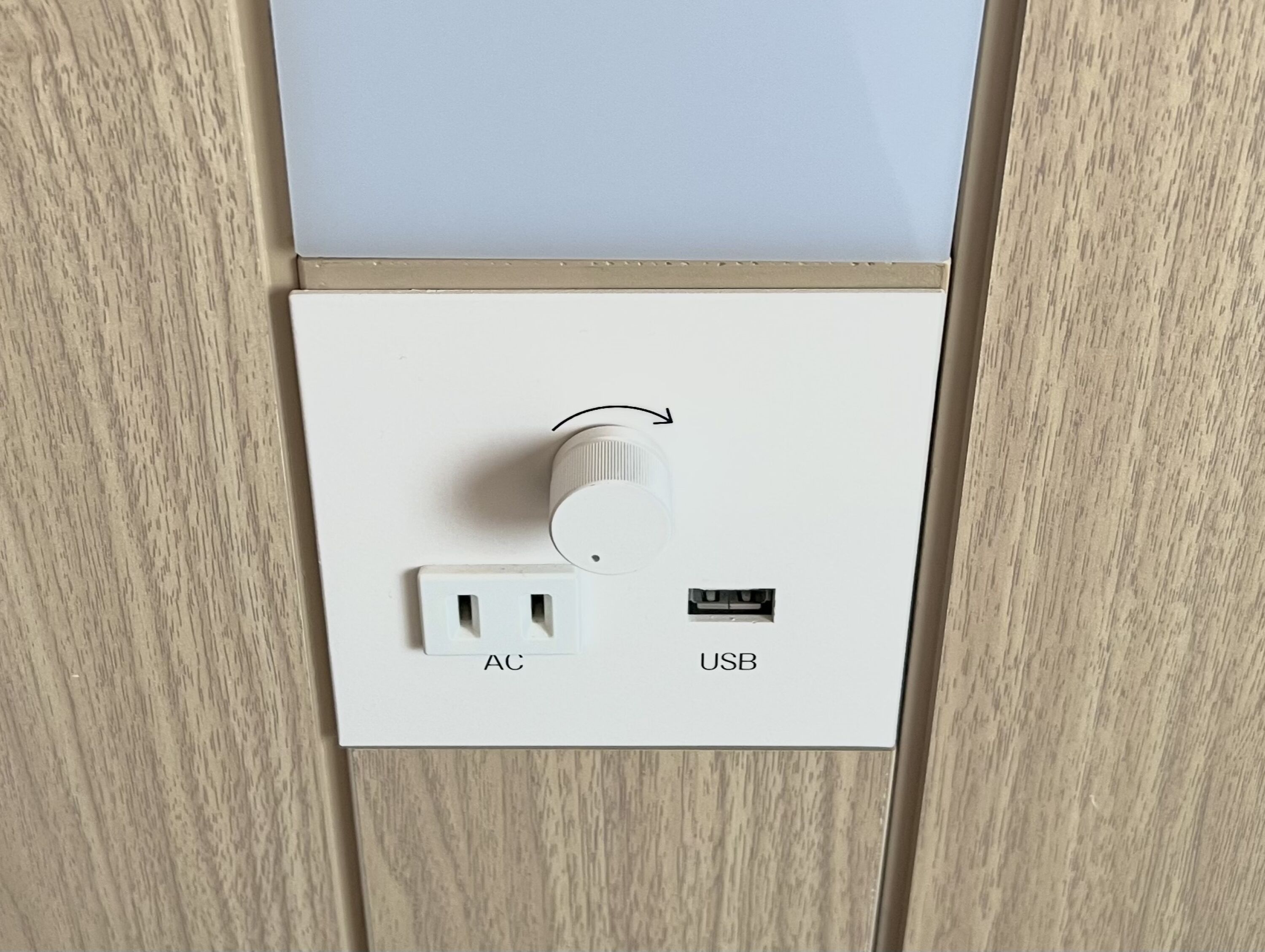 A wall-mounted electrical outlet with an AC and USB port.