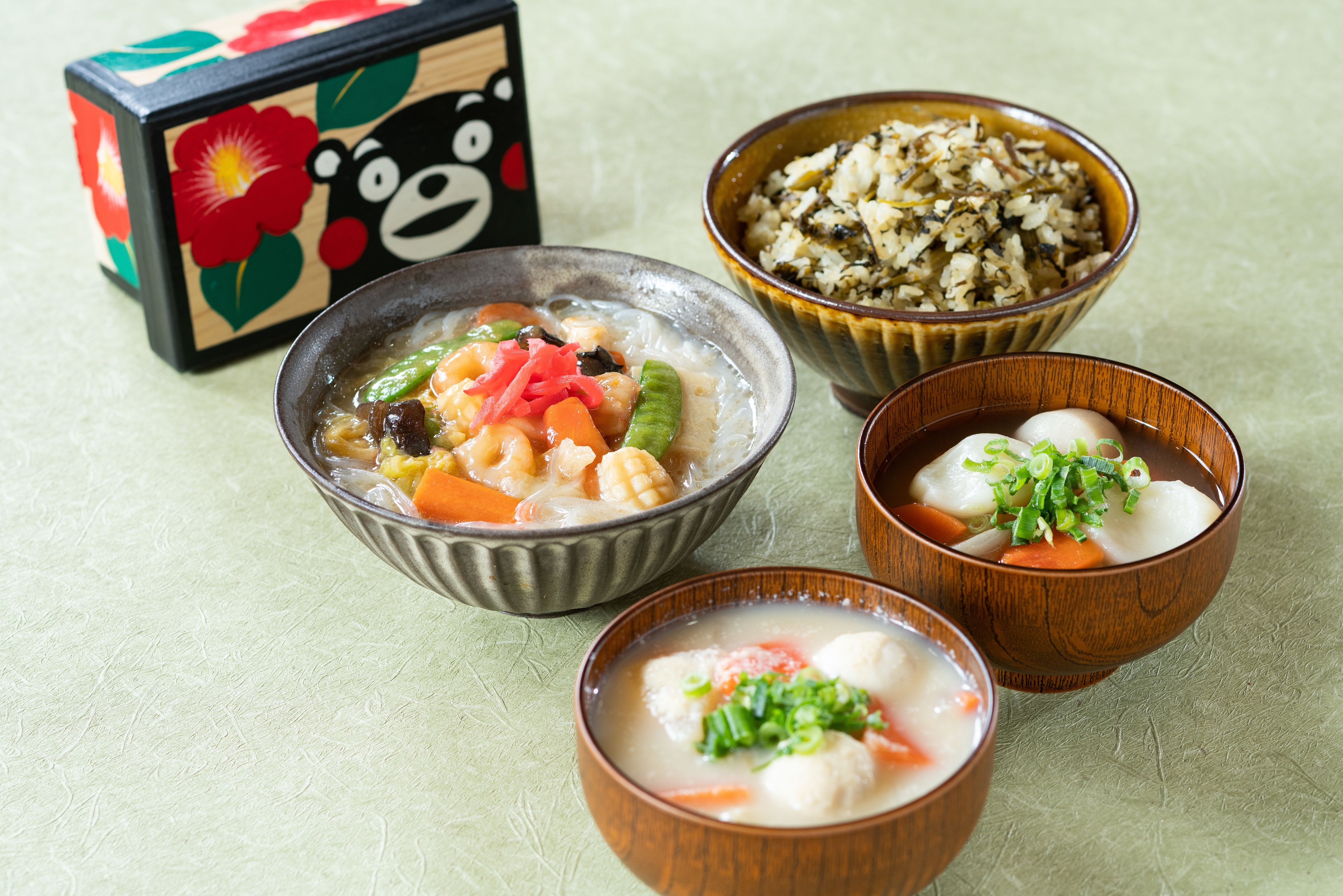 A table with three bowls of food and a decorative box.