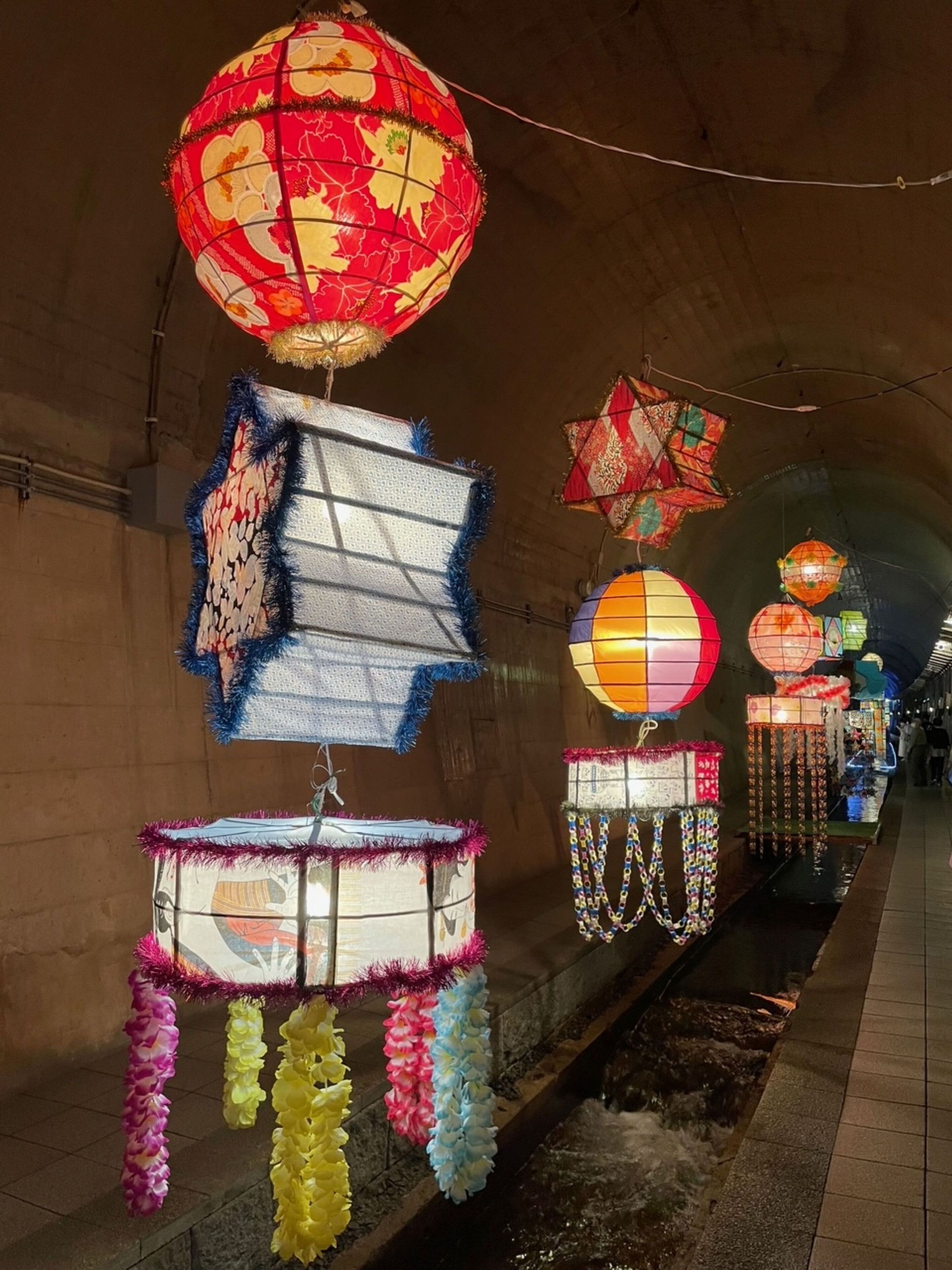 A tunnel adorned with various lanterns and decorative items.