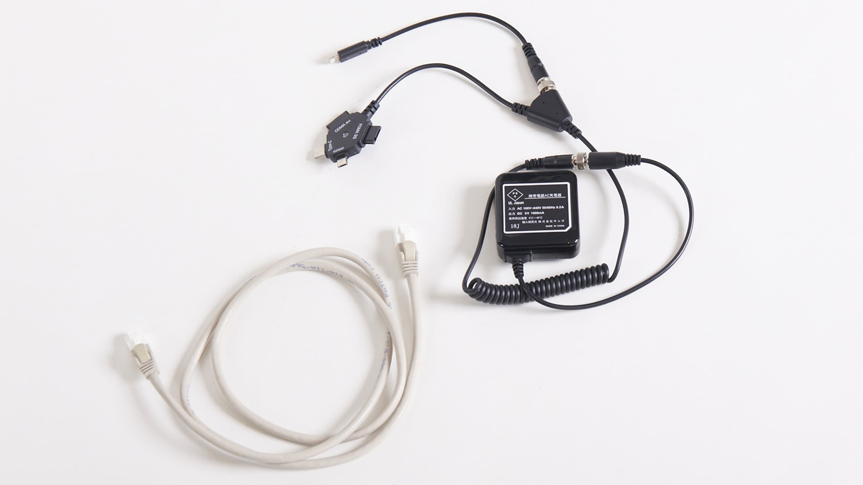 A power adapter with a coiled cable and a USB cable.