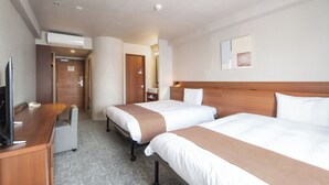 Une chambre d’hôtel avec deux lits, un bureau, une télévision et un appareil de climatisation.