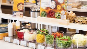 Un buffet de salades proposant une variété de légumes et de condiments.